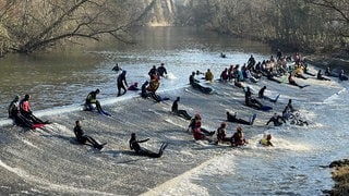 Kocherabschwimmen in Schwäbisch Hall an Silvester ist Tradition. Die Schwimmer rutschen eine Rampe im Fluss herunter.