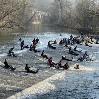 Kocherabschwimmen in Schwäbisch Hall an Silvester ist Tradition. Die Schwimmer rutschen eine Rampe im Fluss herunter.