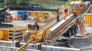 Bauarbeiter stehen auf dem Bohrer, der die ersten Bohrarbeiten für die Stromautobahn Suedlink vollzieht.