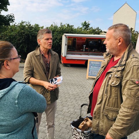 Ingo Wellenreuther im Gespräch auf dem Wochenmarkt in Karlsruhe Neureut