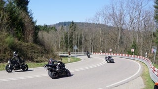 Mehrere Motorräder sind bei Sonnenschein auf der B500 unterwegs.