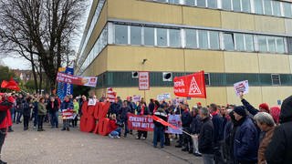 Streikende mit Bannern und Fahnen vor dem Witzenmann-Gebäude in Pforzheim