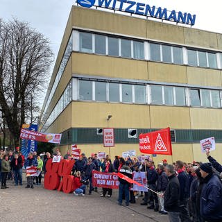 Streikende mit Bannern und Fahnen vor dem Witzenmann-Gebäude in Pforzheim