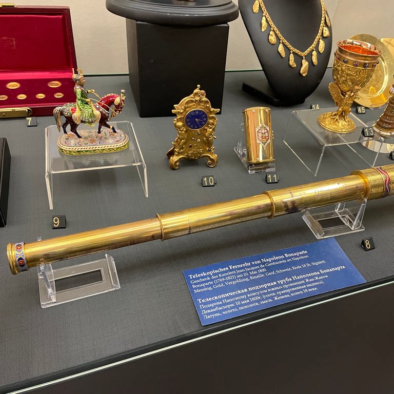 Eine Vitrine des Fabergé-Museum in Baden-Baden mit Goldschmuck und goldener Uhr