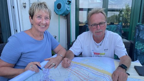 Zwei Anwohner in Bühl sitzen über einem Plan der neuen Stromtrasse