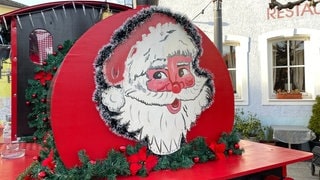 Ein großes Weihnachtsmanngesicht auf einer Bude auf dem Bruchsaler Wintermarkt