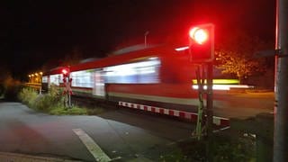 Zug überquert bei Dunkelheit einen geschlossenen Bahnübergang