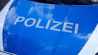 Kühlerhaube eines Polizeiautos mit der Aufschrift "Polizei"