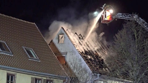 Feuerwehrleute auf Drehleiter löschen Wohnhausbrand