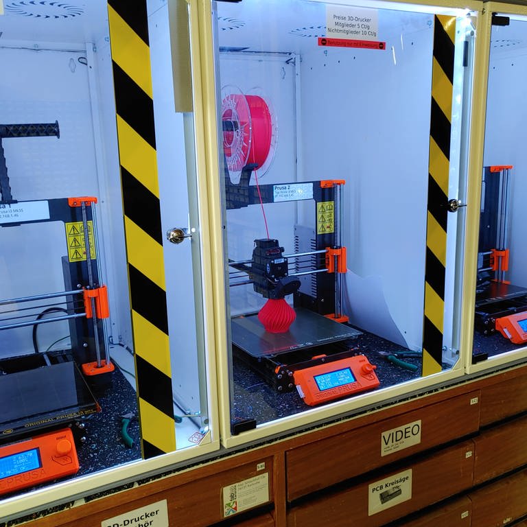 Drei 3D-Drucker sind zu sehen, auf einem wird eine Vase gedruckt