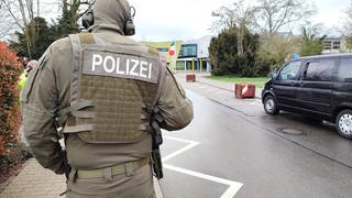 Polizist einer Sondereinheit steht vor dem Schulgebäude in Blankenloch
