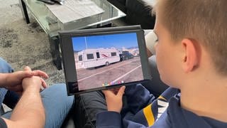Ein Junge sieht sich ein Foto auf einem Tablet an
