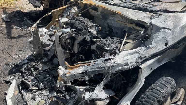 Ein völlig zerstörter Motorraum eines abgebrannten Autos in Karlsruhe