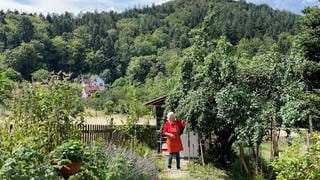 Lucia Förderer steht in ihrem Garten in Ebersteinburg vor ihrem 100 Jahre alten Zwetschgenbaum