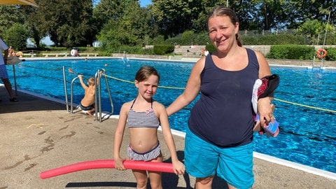 Schwimmkurs für Kinder im Wartbergbad in Pforzheim - eie Frau steht mit einem Mädchen am beckenrand, das Mädchen hat eine rote Schwimmnudel in der Hand