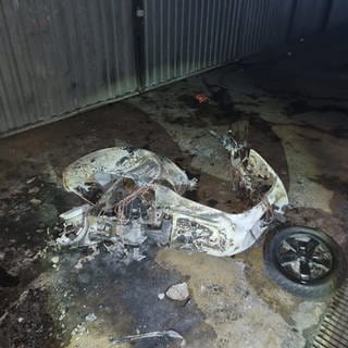 Ein Roller liegt nach einem Brand in einer Tiefgarage in Karlsruhe auf dem Boden.