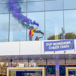 Klima-Aktivisten demonstrieren mit Bengalo-Fackeln auf dem Vordach des Baden-Badener Kongresshauses