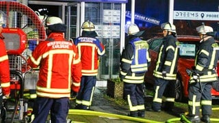 Feuerwehrmänner vor dem Eingang eines Autohauses