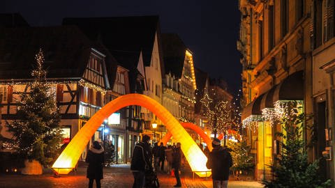 In Dunkeln wird der Weihnachtsmarkt in der Innenstadt von Bretten mit Lichterketten beleuchtet.