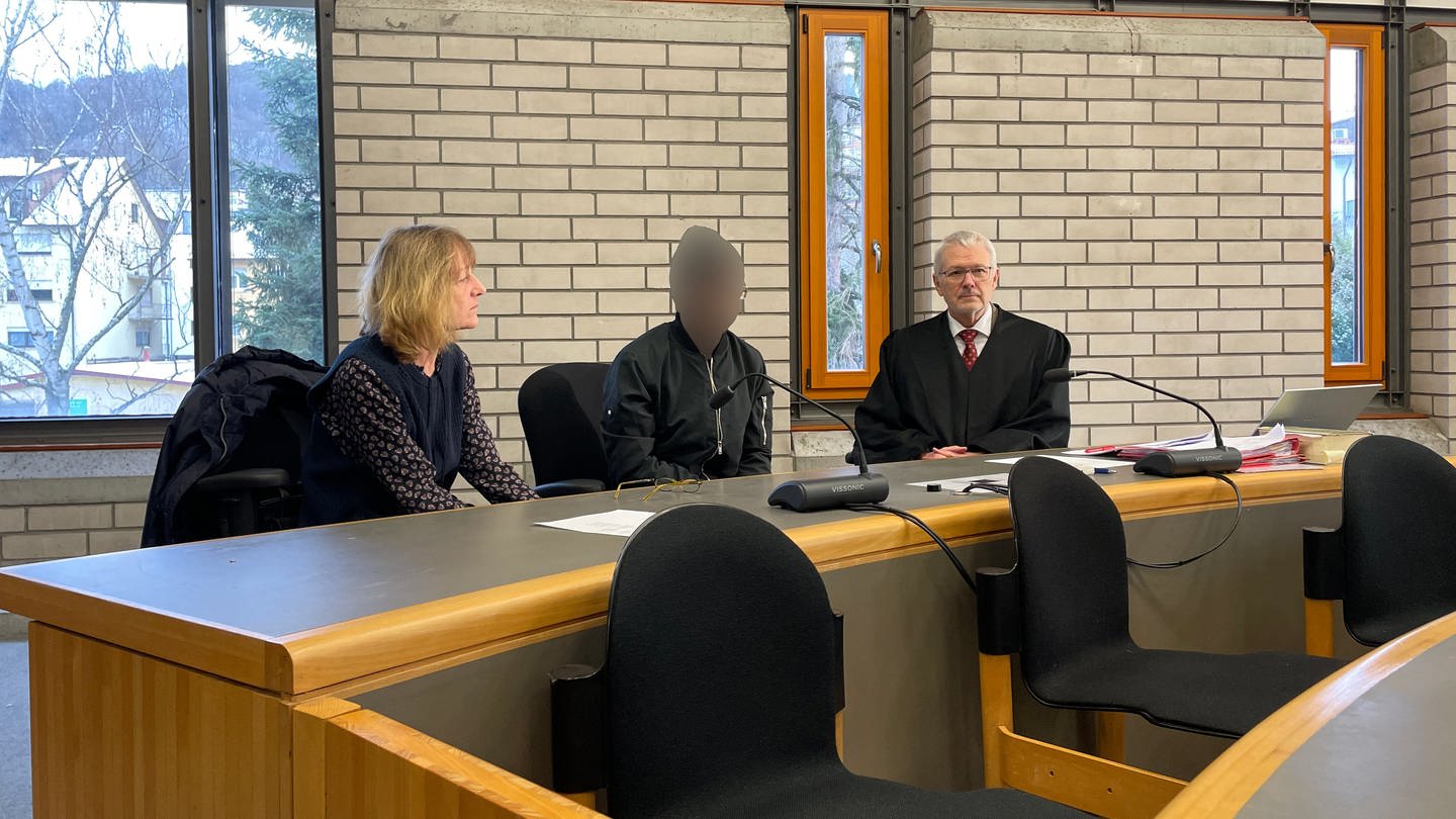 Prozessbeginn am Landgericht Baden-Baden, Angeklagter und zwei Anwälte sitzen im Gerichtssaal