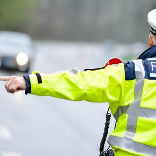 Ein Autofahrer fuhr auf seiner Flucht vor einer Polizeikontrolle eine Frau in Gaggenau an. Polizei macht Haltesignal für einen Autofahrer.