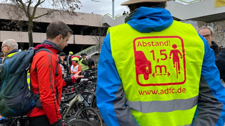 Auf der gelben Ordnerweste eines ADFC-Mitglieds bei der Demo in Gedenken an "Natenom" in Pforzheim steht "Abstand 1,5 Meter".