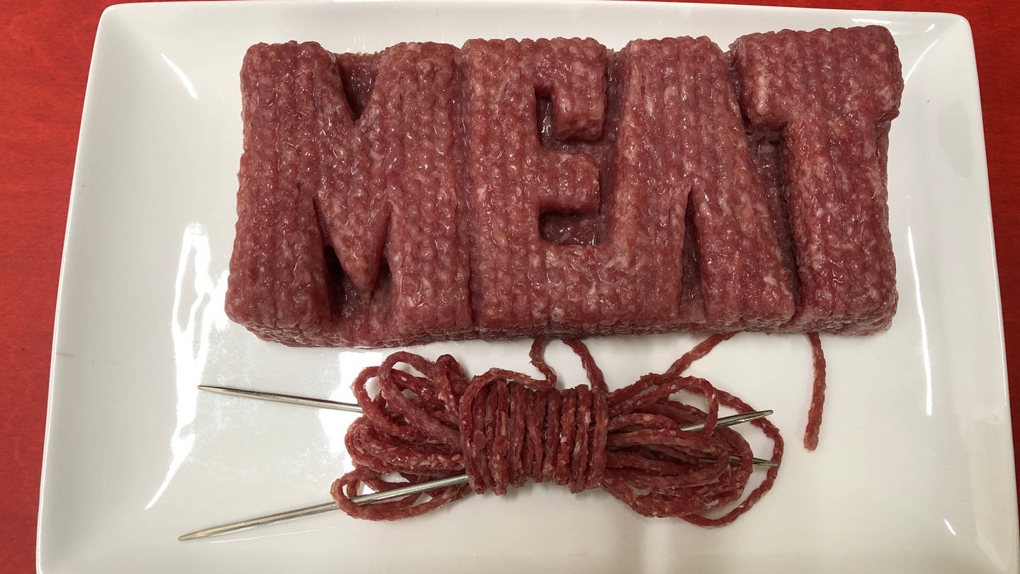 Der Schriftzug Meat liegt auf einem Teller, gestrickt