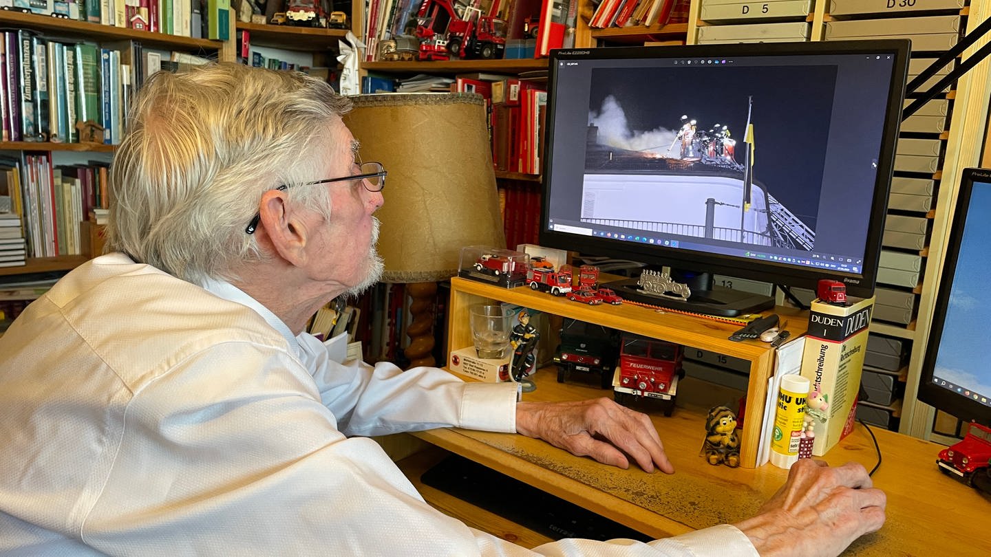 Bertold Wagner sichtet am Computer Fotos von den Brandeinsätzen