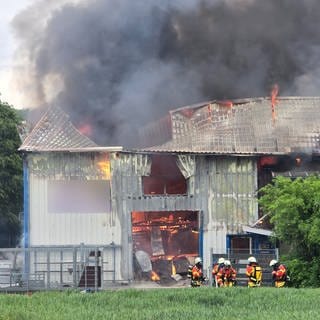 Am Dienstagabend kam es zu einem Brand im Aussiedlerhof Sohl in Weingarten im Kreis Karlsruhe. Das Dach des Gebäudes ist eingestürzt. Flammen und Rauch steigen aus dem Gebäude auf.