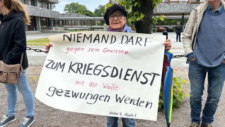 Der Lieblingsartikel aus dem Grundgesetz in der Hand einer Teilnehmerin der Menschenkette in Karlsruhe um das Bundesverfassungsgericht.