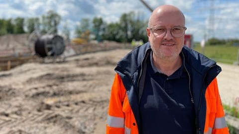 Projektleiter Martin Höhner steht auf der Baustelle bei Rheinau. Er weiß, worauf es ankommt, damit sowohl Gas als auch Wasserstoff durch die Leitungen fließen kann.