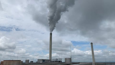 Das Kohlekraftwerk in Karlsruhe am Rhein von außen mit einem rauchenden Schornstein 