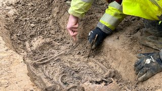 Bei Bauarbeiten gefunden: In Karlsruhe Durlach wurden 22 Skelette auf einem unbekannten Friefhof entdeckt. Archäologen graben ein Skelett aus.