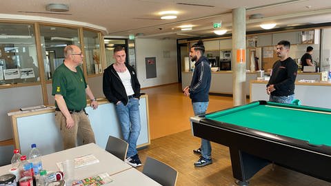 In den Räumen der forensischen Psychiatrie Calw wurde der Tatort gedreht. Junge Männer um einen Billiard-Tisch herum in einem größeren Raum.