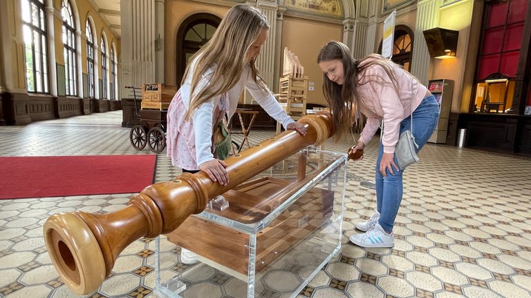 In der Kindermusikwelt Toccarion in Baden-Baden bestaunen zwei Mädchen ein überdimensionales Holzblasinstrument