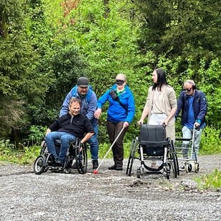 Gruppe von Kursteilnehmern, einer mit Rollator, eine mit Blindenstock udn Blindenmaske. Der Naturpark Schwarzwald bietet ein Inklusions-Schulung für seine Guides an