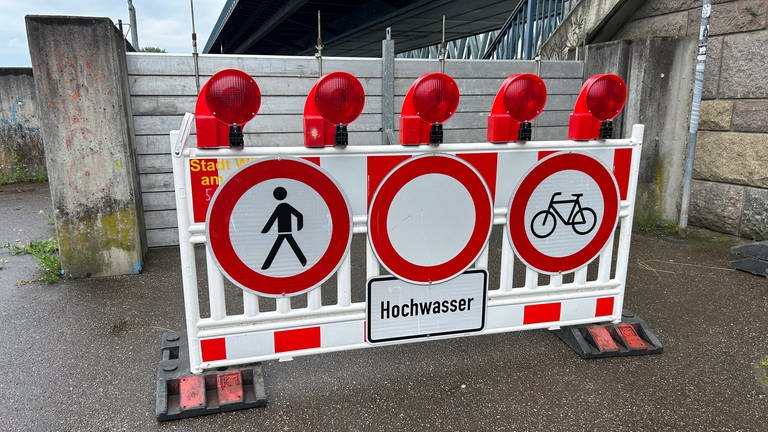 Ein Schild warnt vor Hochwasser am Rhein.