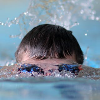 Ein Schwimmer schwimmt in einem Hallenbad