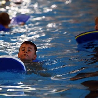 Ein Kind bei einem Schwimmkurs im Becken.