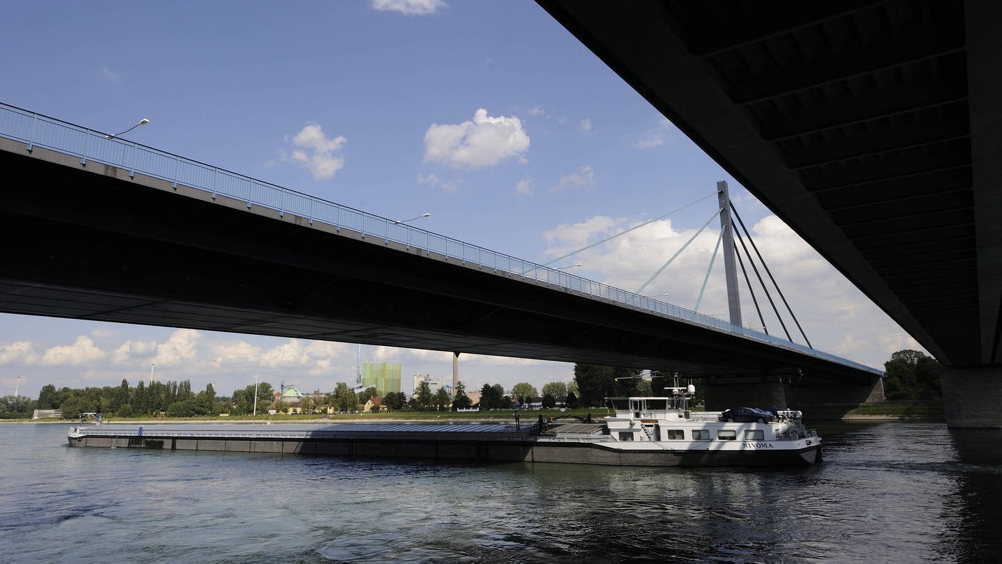 Frachtschifff fährt unter Rheinbrücke bei Karlsruhe durch
