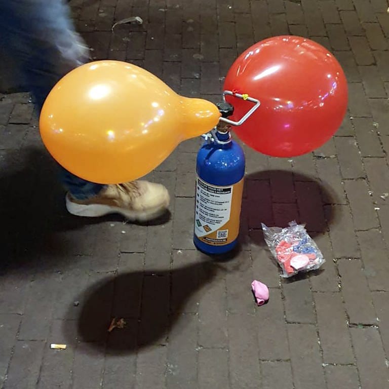 Kartusche voll mit Lachgas und Luftballons; das Rauschmittel wird immer beliebter. Vor kurzem hat es ein Vorfall bei Baden-Baden gegeben. 