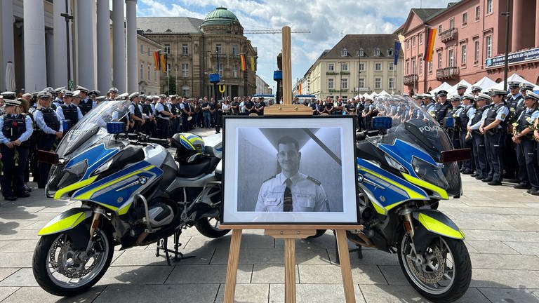 Mit einer Schweigeminute auf dem Karlsruher Marktplatz gedenken Polizisten ihres getöteten Mannheimer Kollegen.