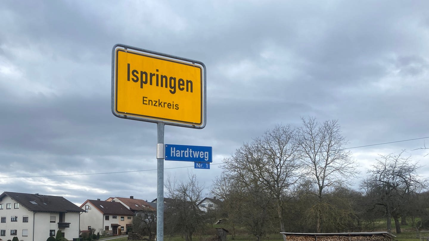 Ortsschild von Ispringen. Im Hintergrund sind eine Wiese und ein paar Häuser zu sehen.  Am Tag der Europawahl hat eine knappe Mehrheit bei einem Bürgerentscheid für die Weiterentwicklung eines Neubaugebietes gestimmt.