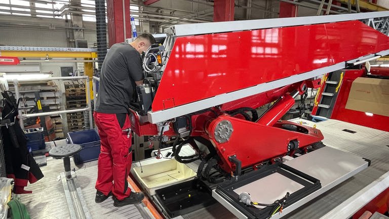 Ein Mitarbeiter der Firma Rosenbauer in Karlsruhe montiert die Drehleiter auf ein neues Feuerwehrfahrzeug.