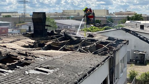 Feuerwehr im Brandeinsatz in Graben Neudorf. Dort brannt am Dienstag eine Lackiererei aus. Zwei Feuerwehrleute auf der Drehleiter bei Nachlöscharbeiten