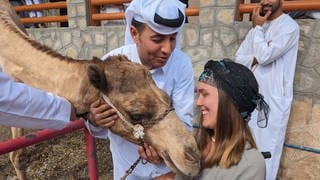 Nora Welsch im Rollstuhl auf Weltreise: Auf Tuchfühlung mit einem Kamel im Oman.