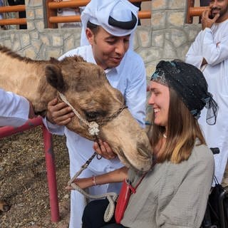 Nora Welsch im Rollstuhl auf Weltreise: Auf Tuchfühlung mit einem Kamel im Oman.