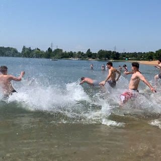 Ein Magnet für Wasser-und Sonnenhungrige: der Hardtsee bei Ubstadt (Kreis Karlsruhe). Junge Männer laufen mit viel Vergnügen ins Wasser
