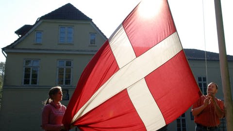 Die dänische Fahne, der Dannebrog, wird gehisst