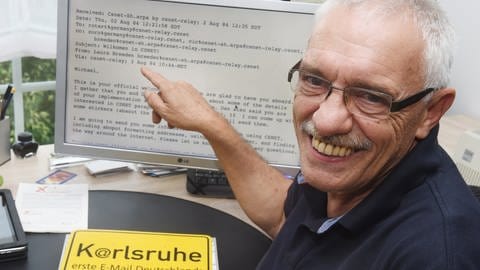 Michael Rotert vor einem Computerbildschirm mit der ersten E-Mail Deutschlands